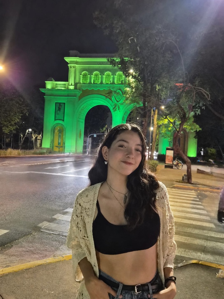 Joven frente a los Arcos de Guadalajara iluminados de verde