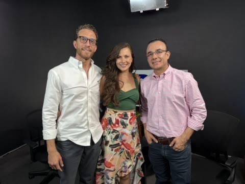 Tres adultos sonriendo en un estudio de televisión